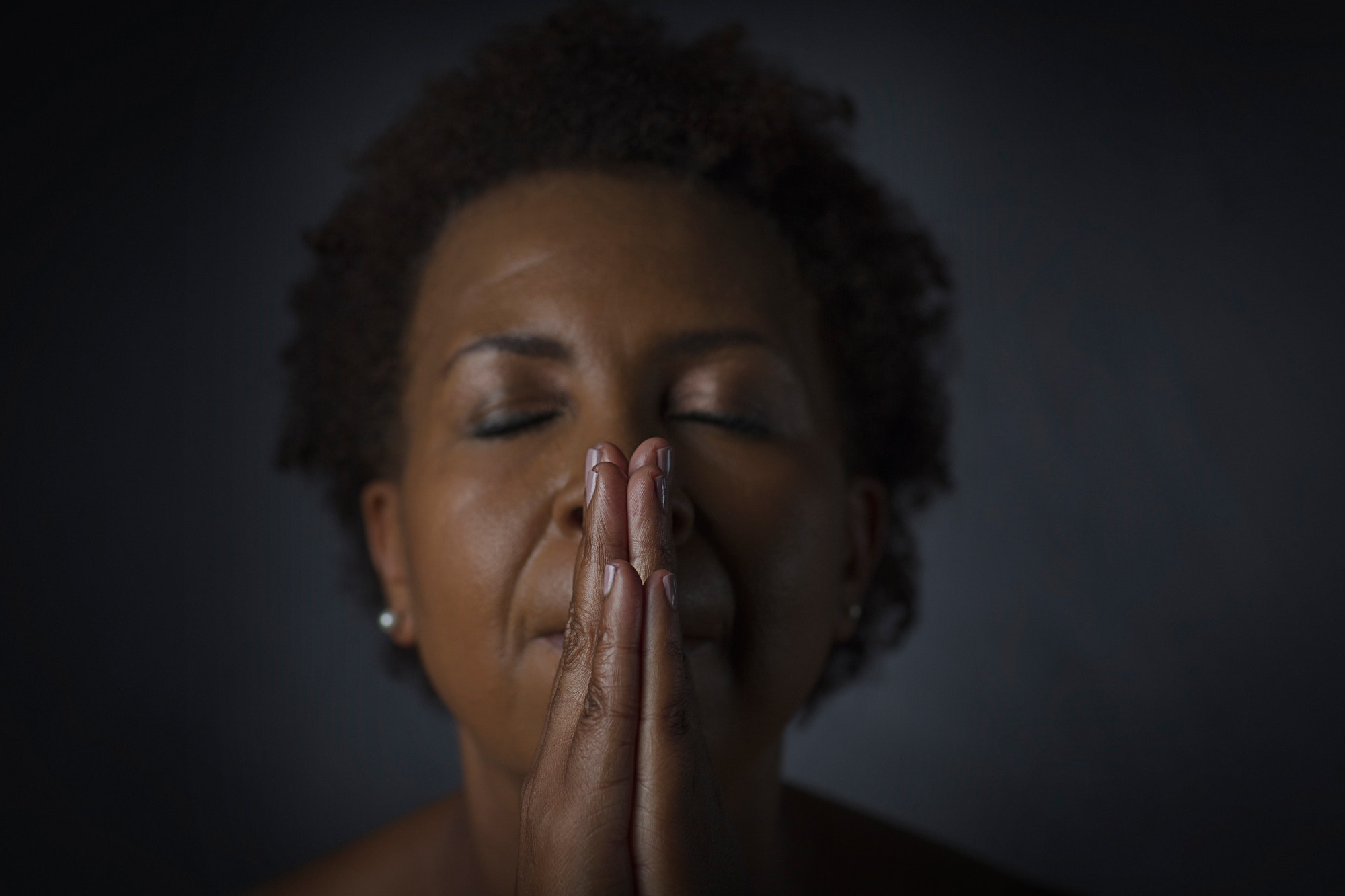 Studio portrait of mature woman praying